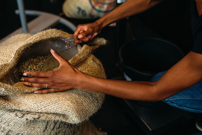 Midsection of man holding coffee beans in shop