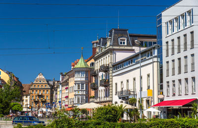 Buildings in city against clear blue sky