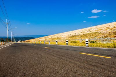 Road by mountain against blue sky