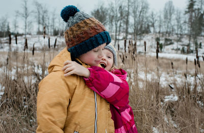 Boy wearing hat on field during winter