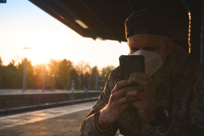 Young man using mobile phone, sbahn station