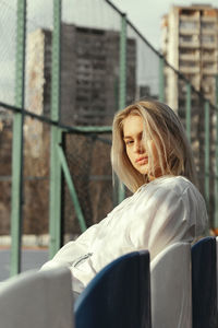 Woman looking away while sitting outdoors