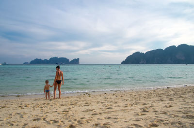 People at beach against sky