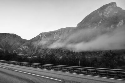 Road by mountains against sky