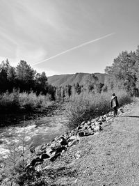 Man walking on mountain against sky