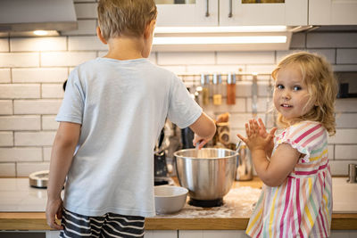 Rear view of boy holding food at home