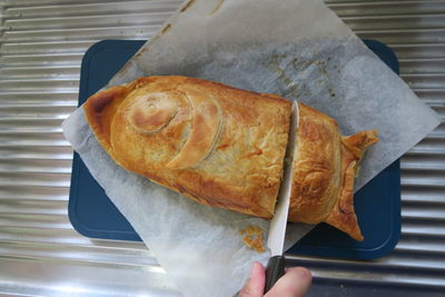 High angle view of person holding bread on table