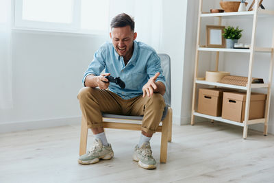 Portrait of young man sitting on sofa at home