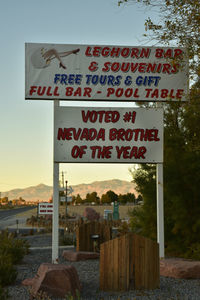 Close-up of road sign against sky