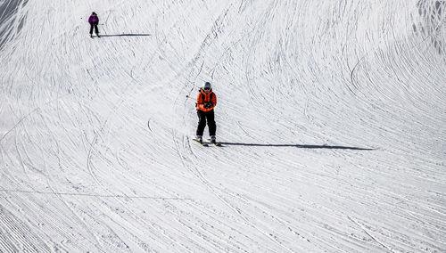 High angle view of people skiing on snow covered mountain