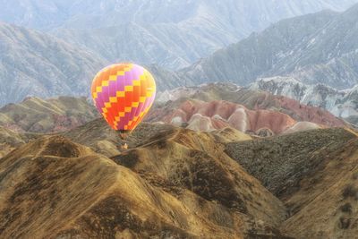 Hot air balloon flying over mountain
