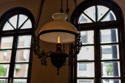 Low angle view of illuminated pendant light hanging from ceiling