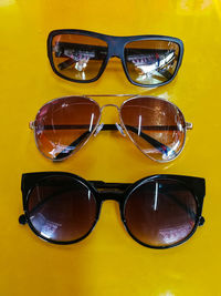 Close-up of sunglasses against yellow background