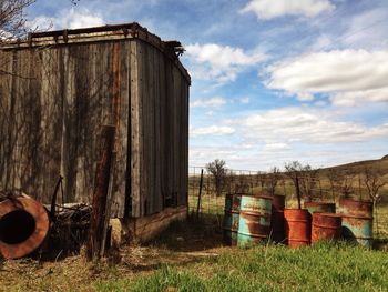 Barn on field against cloudy sky