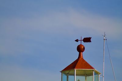 Low angle view of weather vane against sky
