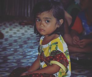 Portrait of cute girl sitting outdoors