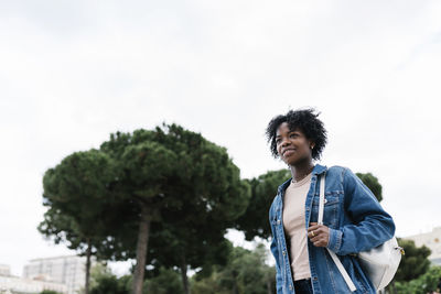 Afro woman carrying backpack walking in city