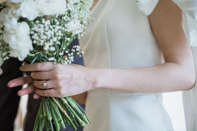 Midsection of woman holding flower bouquet