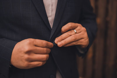 Midsection of businessman using mobile phone