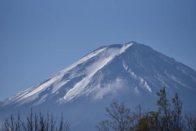 Low-angle view of mt. fuji covered with snow against a clear blue sky