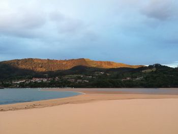 View of calm beach against mountain range