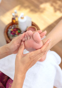 Cropped hands of woman giving feet massage to customer