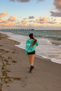 Full length rear view of man standing on beach