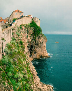 Scenic view of sea by buildings against sky