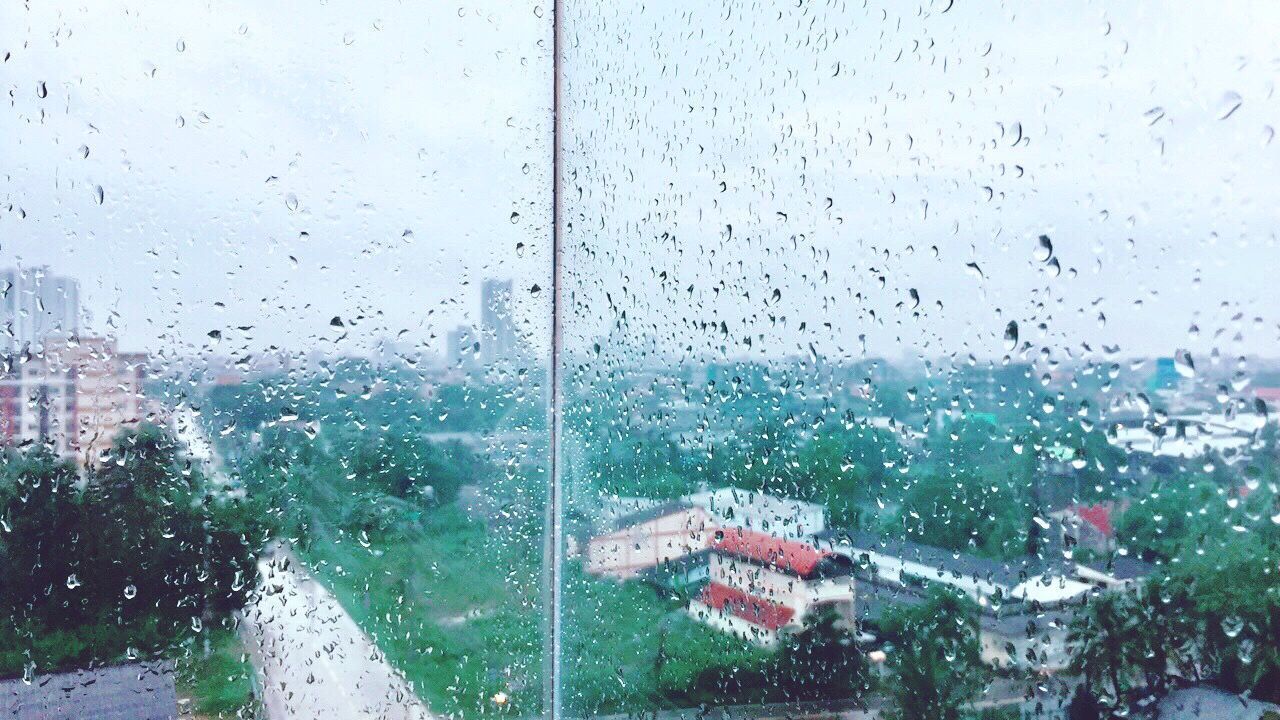 CLOSE-UP OF WET WINDOW IN CITY