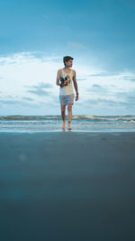 Full length of teenage girl standing on beach