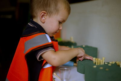 Little toddler dressed as a builder playing at home