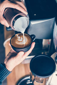 Cropped hands of man preparing coffee in cafe
