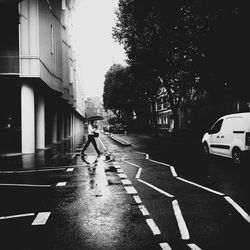 Man crossing road in rain