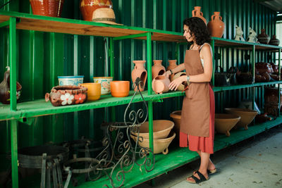 Rear view of woman standing on barbecue grill