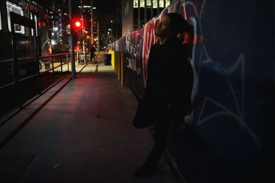 Woman in illuminated city at night