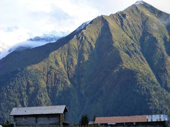 Houses on mountain against sky