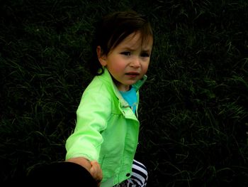 Portrait of girl standing on grassy field