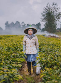 Portrait of senior woman standing at farm