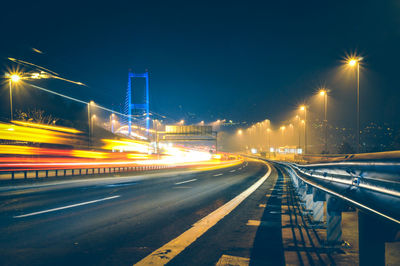 Light trails on road against sky at night