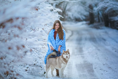 Young woman with dog in snow