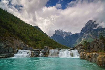 Scenic view of waterfall against sky