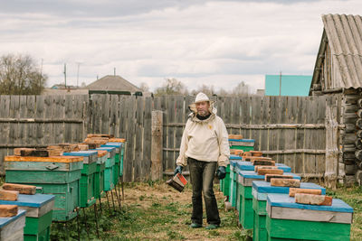 Beekeeper in a protective suit among the hives