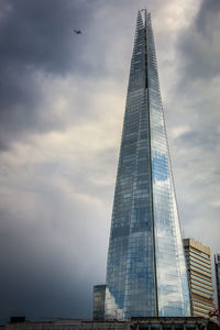 Low angle view of modern building against cloudy sky