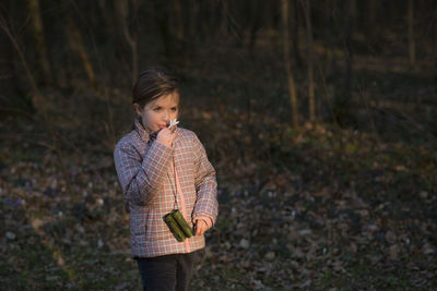 Cute girl smelling flower in forest