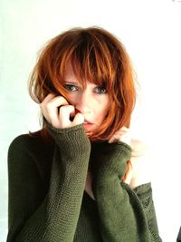 Portrait of depressed woman standing against white background