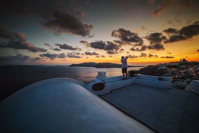 Scenic view of sea against cloudy sky at sunset