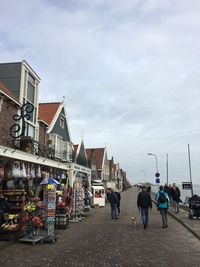 People walking on street against sky