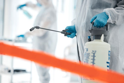 Midsection of scientist examining chemical in laboratory