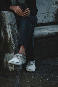 Low section of man standing against wall