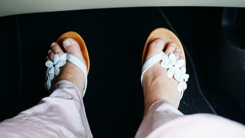 Low section of woman wearing flip-flop